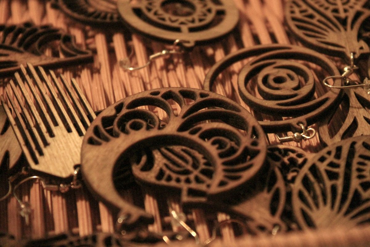 Laser-cut plywood earrings with lace-like swirl and leaf patterns